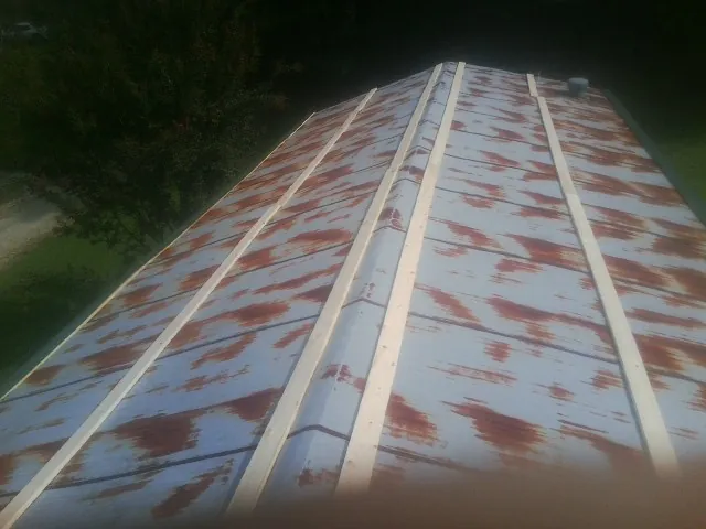 Rusted metal roof panels with new wood purlins before replacement — Storm Damage Roof Repair in Gilman by Roofing Brothers